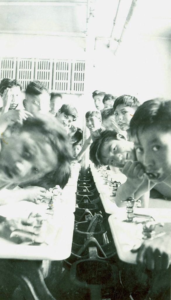 Old Sun School, Gleichen, Alta. - Boys at morning wash up. - [194-?]. P75-103-S7-191 from The General Synod Archives, Anglican Church of Canada