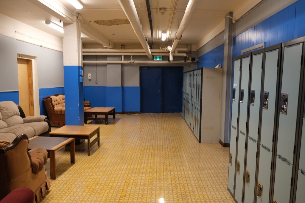 UnBQ east side of basement, entrance to the gym addition. Formerly the north part of the boys' playroom, the south side has been converted into a teaching and ceremonial space. Taken during digital documentation, August 2022. From Madisen Hvidberg.