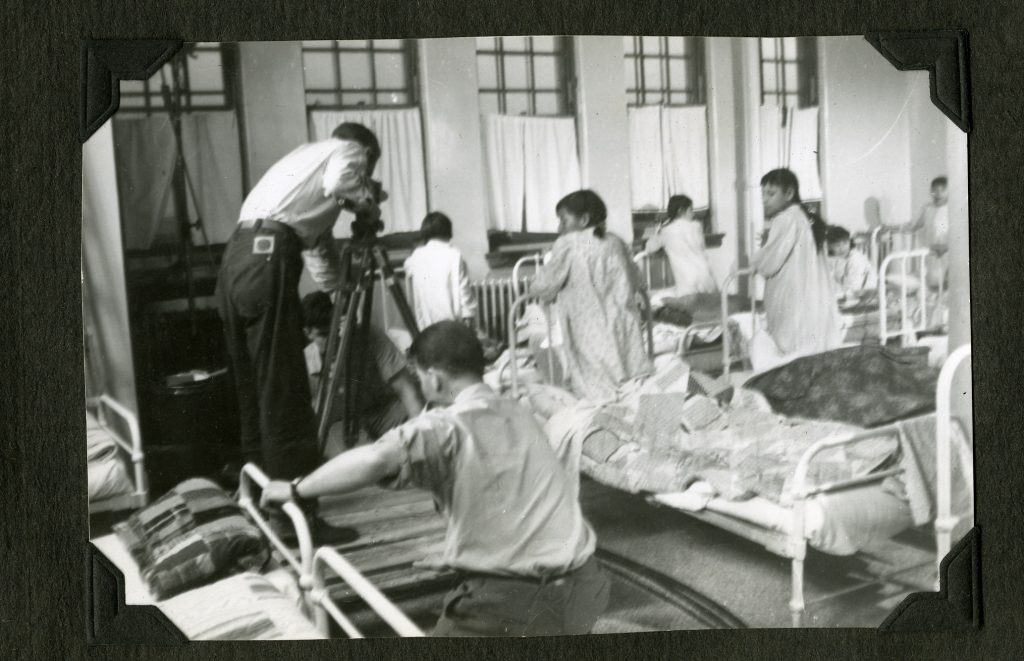 Jr. Boys' Dormitory during the filming of a documentary, with the addition of window coverings and nicer quilts on the beds. Old Sun IRS, 1952. Photo Source: Shingwauk Residential Schools Centre, Algoma University