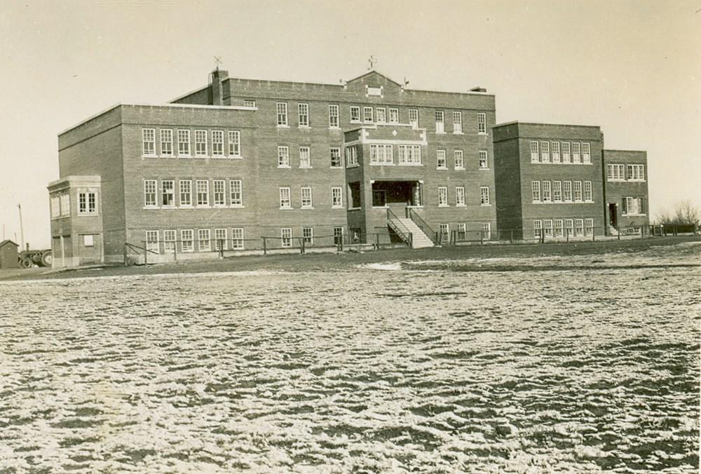 Exterior of Old Sun School, showing the forth floor is slightly shorter than the lower levels of the school.  [193-?]. P7538-1021 from the General Synod Archives, Anglican Church of Canada.