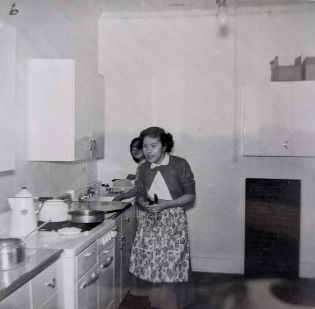 Students in the kitchen in the basement of the main school building, between 1926-1937. PR1985.0100 from The Provincial Archives of Alberta, Open Copyright.