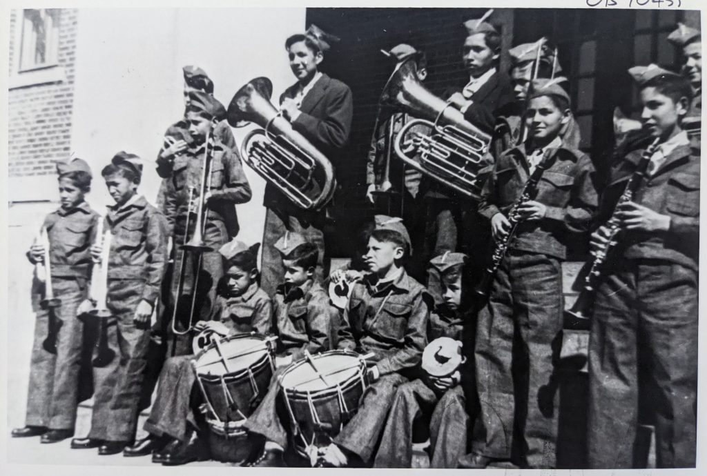 Boys in the school band at main entrance to the school, 1950-1951. OB1045 from The Provincial Archives of Alberta, Open Copyright.