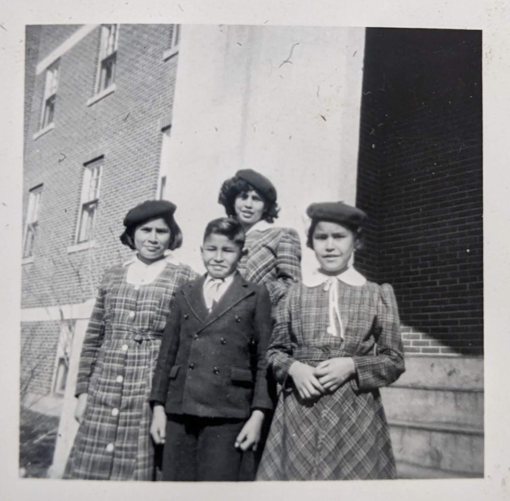 Shirt family at school 1951, standing on steps to the main entrance into the first floor. PR1973.0248/864 from The Provincial Archives of Alberta, Open Copyright.