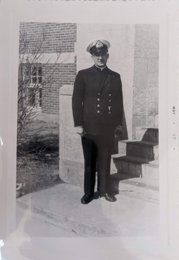 R. P. Bennet Rollande OMI standing at front of school, date unknown. PR1973.0248/287 from The Provincial Archives of Alberta, Open Copyright.