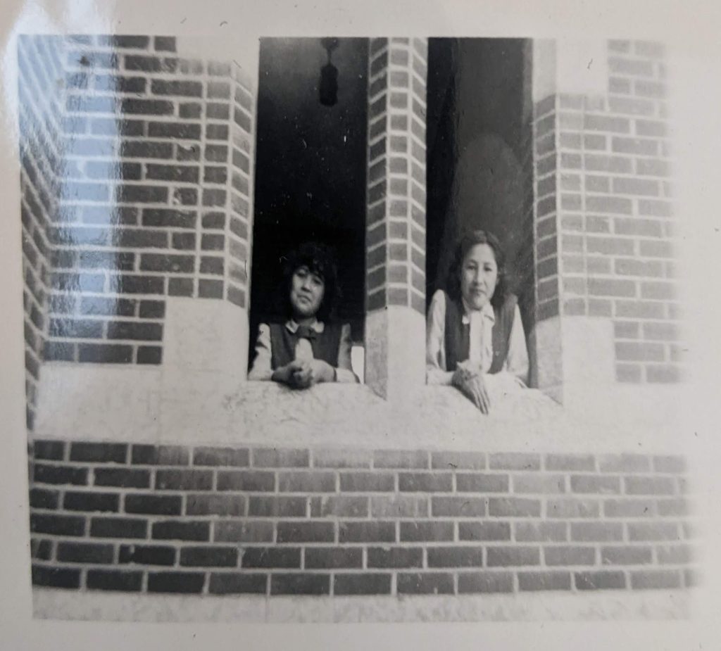 Girls look through alcoves on the side of the front entrance to Blue Quills, 1947-1951. PR1973.0248/864 from The Provincial Archives of Alberta, Open Copyright.