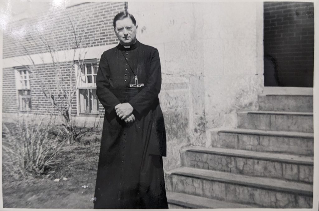 Father Jean Lessard, OMI stands in front of Blue Quills, 1951. PR1973.0248/864 from The Provincial Archives of Alberta, Open Copyright.