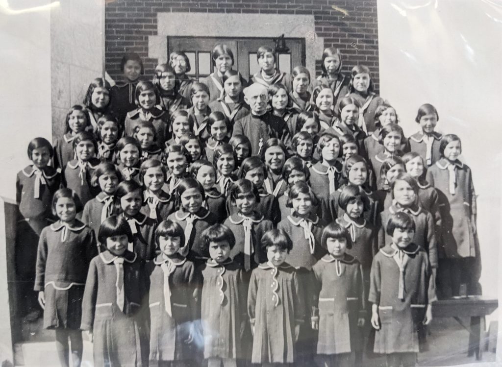 Students on the front steps of Blue Quills with Father Romeo Levert, between 1938-1949. PR1973.0248/864 from The Provincial Archives of Alberta, Open Copyright.