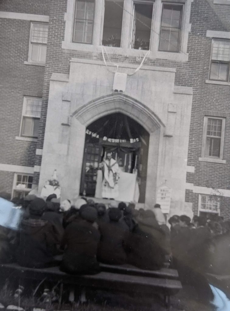 Father Romeo Levert addresses students from front steps of the school, 1938-1949. PR1973.0248/871 from The Provincial Archives of Alberta, Open Copyright.