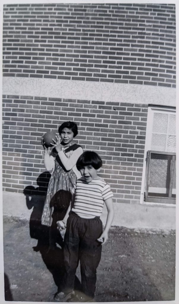 Students posed outside of one of the schools' playrooms, April 1959. PR2010.0475 from The Provincial Archives of Alberta, Open Copyright.