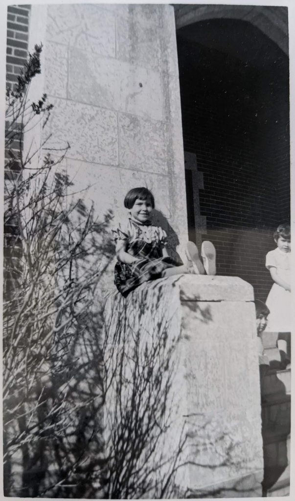 Girl poses on front entrance of Blue Quills, April 1959. PR2010.0475 from The Provincial Archives of Alberta, Open Copyright.