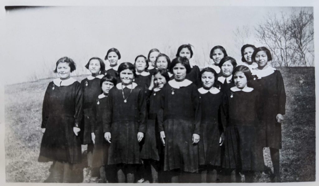 Girls posed on the school grounds, between 1955-1966. PR2010.0475 from The Provincial Archives of Alberta, Open Copyright.