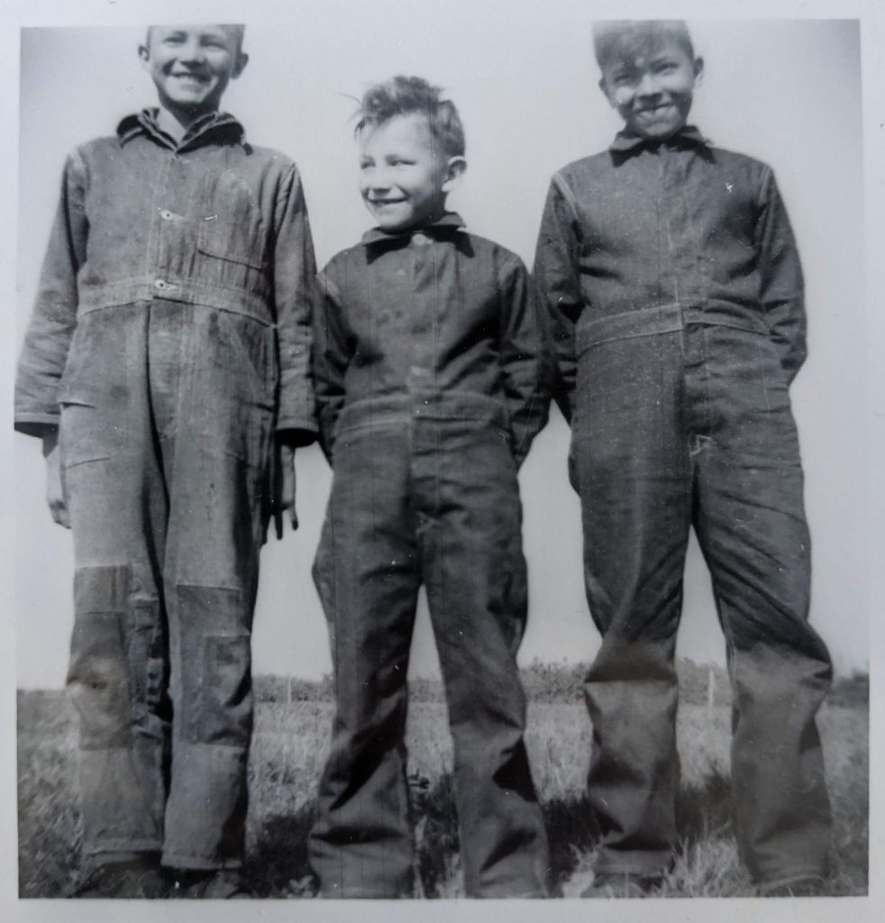 Young students dressed to work, likely either in the boiler room or on the farm that was maintained on the grounds of the school. Between 1959-1966. PR2010.0475 from The Provincial Archives of Alberta, Open Copyright.