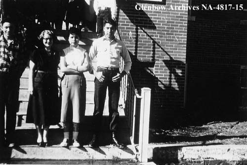 Mildred Richardson, teacher, second from left, with senior students. On front steps into the school, which enter into the central east-west corridor. 1956. NA-4817-15. Courtesy of Glenbow Archives .