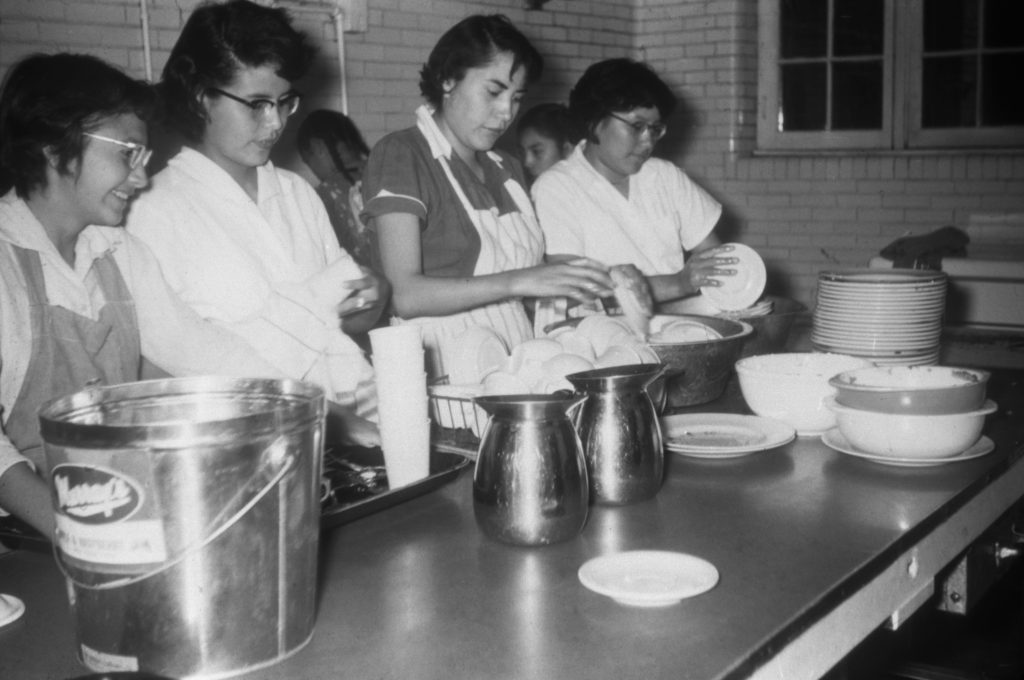 Girls in kitchen washing dishes. From left to right, Daisy Olds, --, Donna Jean Bear, ---. 1955-1957. NA-4817-19. Courtesy of Glenbow Archives .