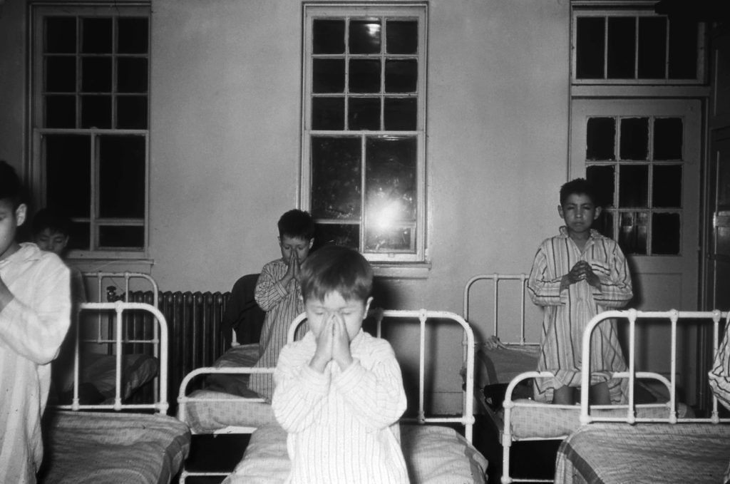 Junior boys' dormitory, Old Sun School. Children saying bedtime prayers. 1955-1957. NA-4817-24. Courtesy of Glenbow Archives .