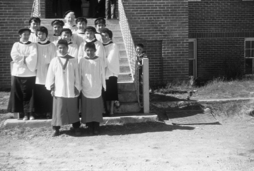 Christmas service choir, on the front steps which lead to the central east-west corridor of the second floor. Girls are wearing berets. 1955-1957. NA-4817-30. Courtesy of Glenbow Archives .