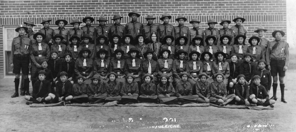 Boy Scouts and Girl Guides wearing their uniforms pose in front of Old Sun. 1933. PA-557-12. Courtesy of Glenbow Archives .